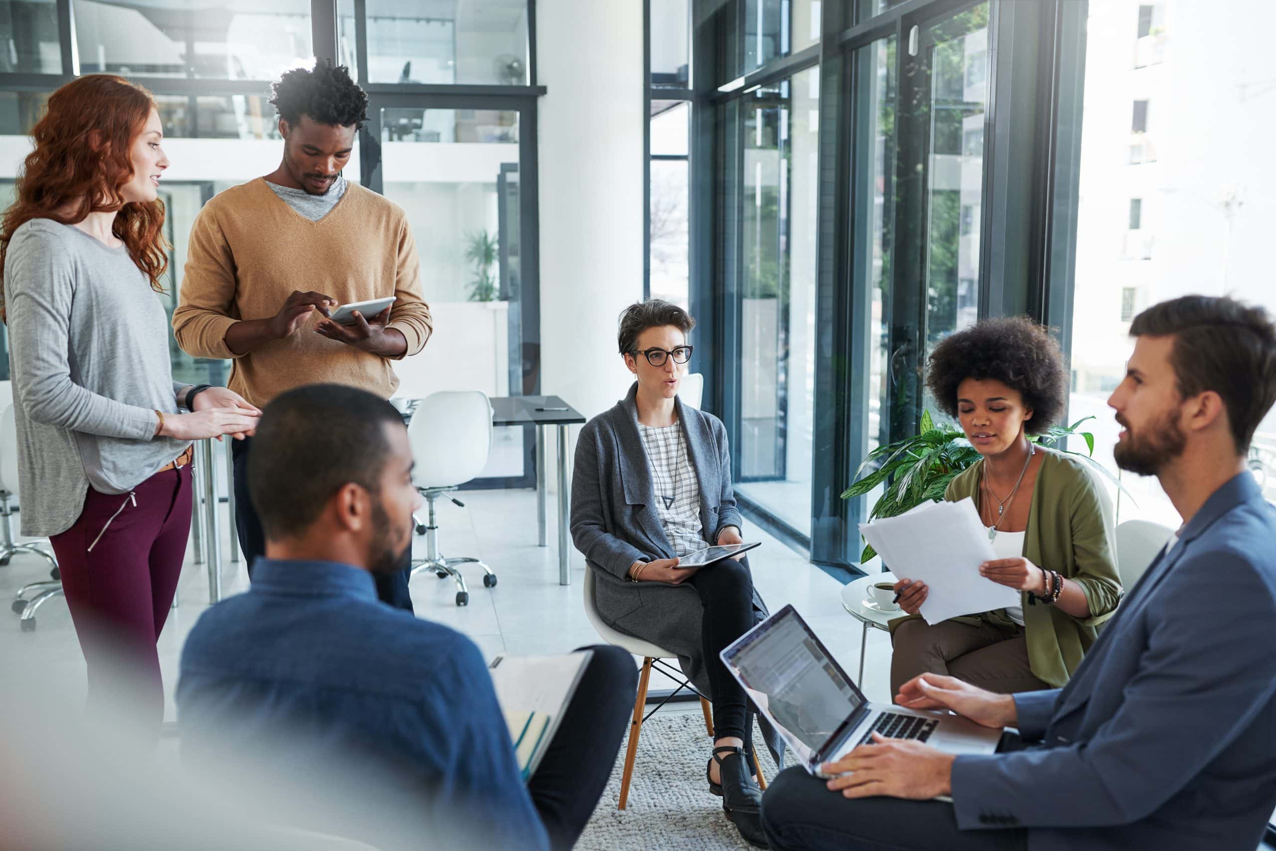 Collaboration, idea and people in meeting with laptop, documents and technology for agenda in office. Discussion, partnership and employees together for plan, work and diversity in creative career