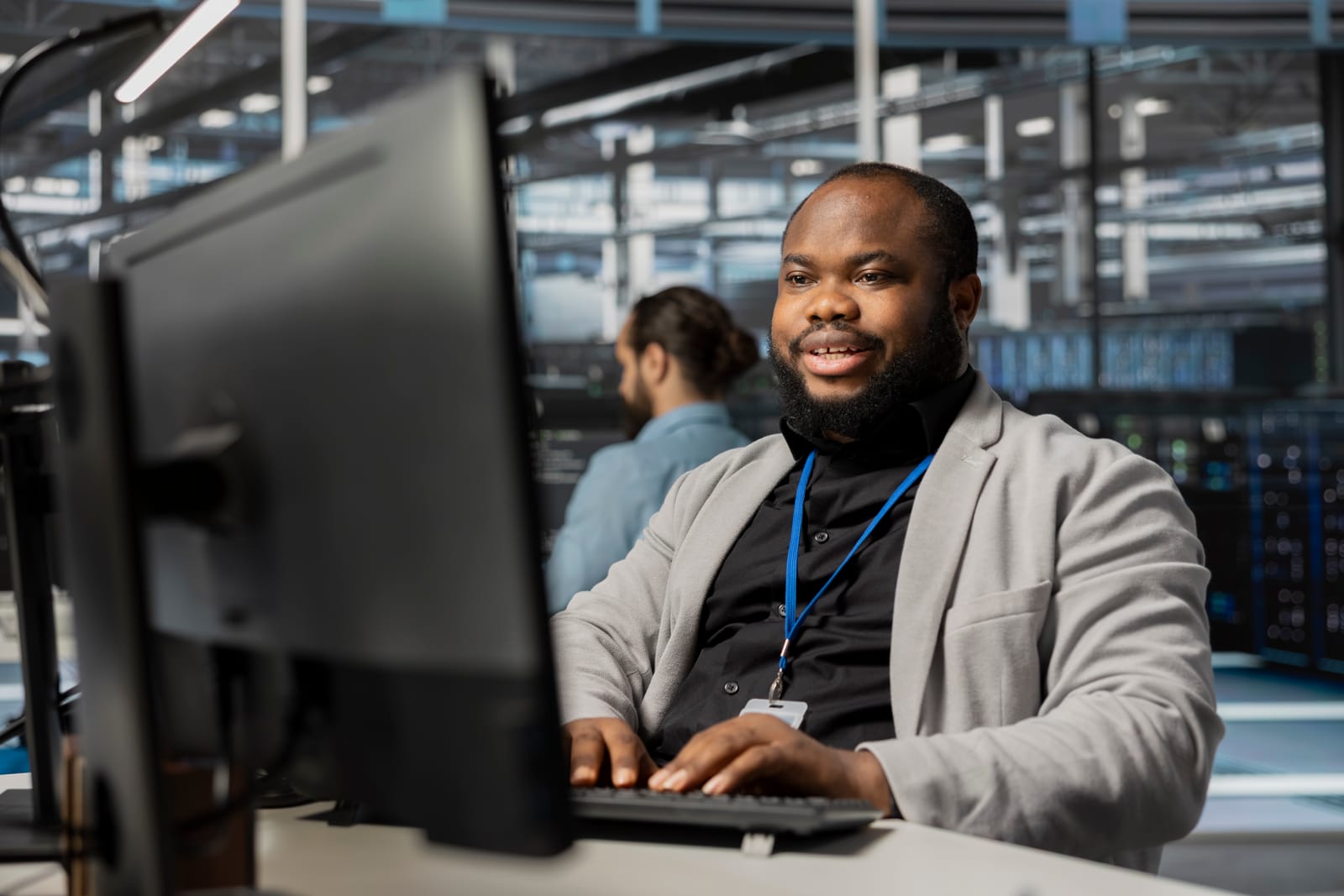 97744414_cheerful-data-center-employee-working-to-update-rackmounts-software
